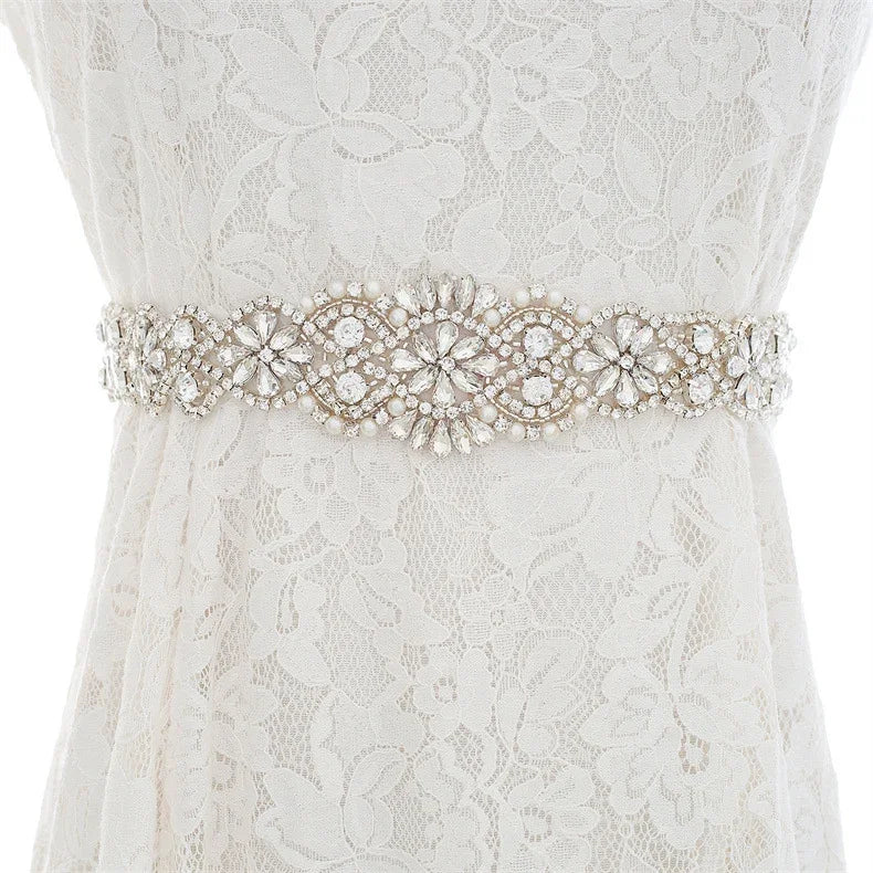 Art Deco inspired rhinestone bridal belt with a prominent center crystal, accessorized on a wedding dress.