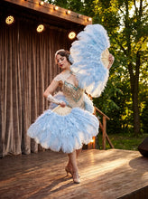 Load image into Gallery viewer, Performer on stage holding a large baby blue ostrich feather fan
