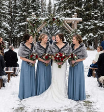 Load image into Gallery viewer, Bridesmaids in blue dresses wearing black and white tipped faux fur wraps in a snowy winter wedding setting.