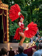 Load image into Gallery viewer, Red ostrich feather fans held by a burlesque dancer at an outdoor stage