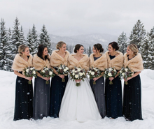 Load image into Gallery viewer, Bride and bridesmaids in fur stoles with bouquets in a snowy landscape