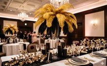 Load image into Gallery viewer, Gold and black ostrich feathers arranged in a wedding centerpiece, elegant decor for formal events and themed parties