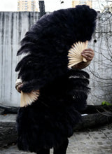 Load image into Gallery viewer, Large black ostrich feather fan, person holding it for burlesque dance performances and costume parties