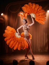 Load image into Gallery viewer, Orange ostrich feather fans held by a burlesque dancer on stage
