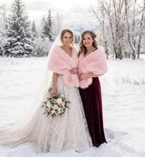 Load image into Gallery viewer, A bride and bridesmaid posing together in the snow, with the bridesmaid wearing a cozy pink faux fur shawl.