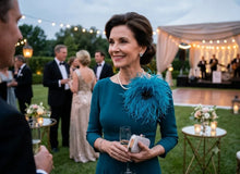 Load image into Gallery viewer, An elegant woman wearing a dark teal dress paired with a matching feather brooch at an evening reception.