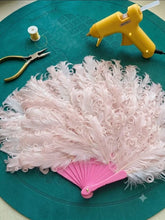 Load image into Gallery viewer, A vintage style pink ostrich feather dance fan on a dark green textured background