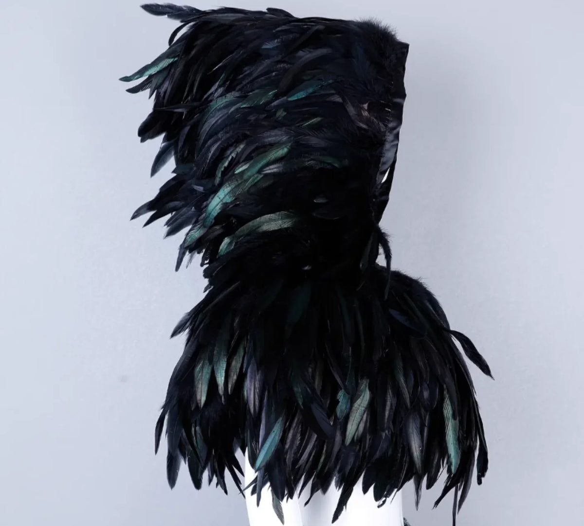Black feathered dress on a mannequin against a light gray background
