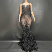 Load image into Gallery viewer, Black beaded evening gown with feathered skirt on a mannequin against a dark background
