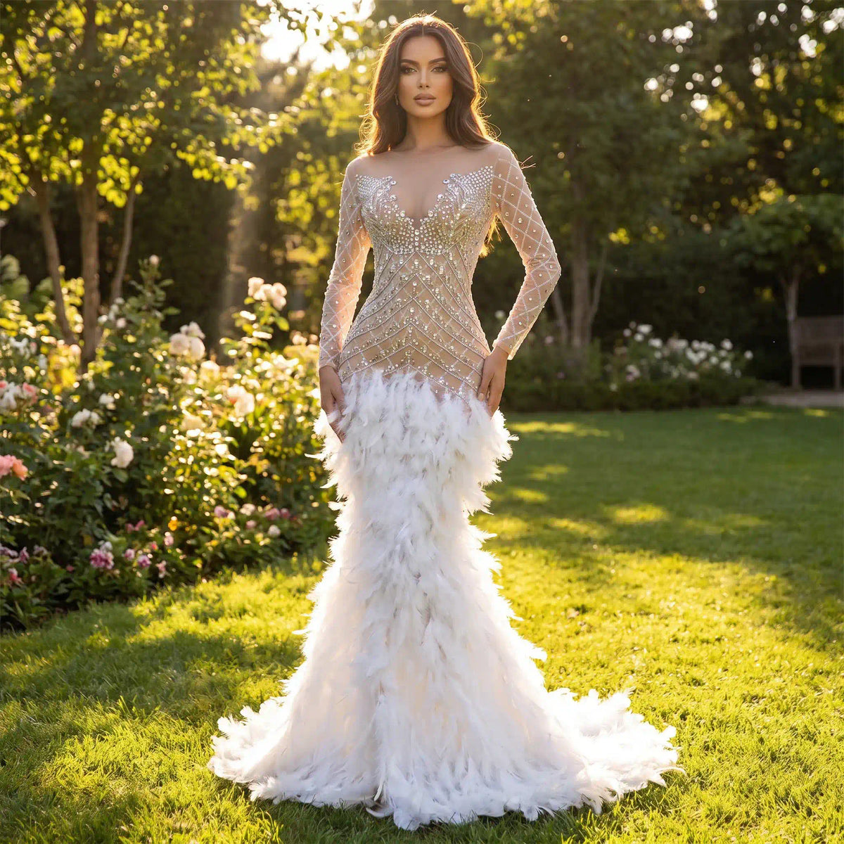 A woman stands in a green garden, wearing a sheer, long-sleeve evening gown[cite: 9] adorned with sparkly silver rhinestones[cite: 9] on the bodice and a dramatic white feather mermaid skirt