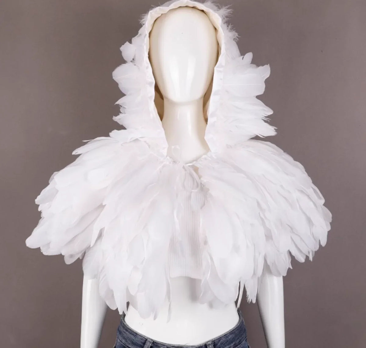 Mannequin wearing a white hooded garment with feather-like details on a gray background