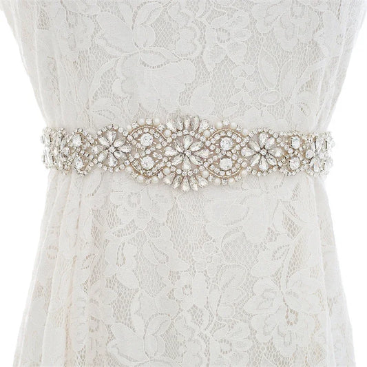 Art Deco inspired rhinestone bridal belt with a prominent center crystal, accessorized on a wedding dress.