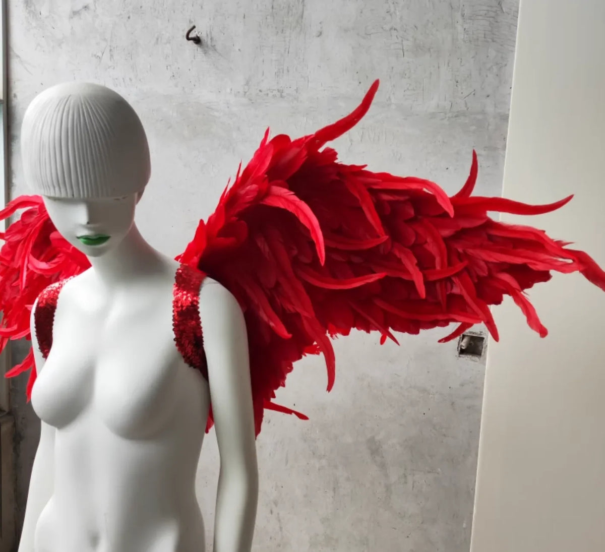 Asymmetrical red feather devil wings, unique costume accessory for creative photoshoots and events