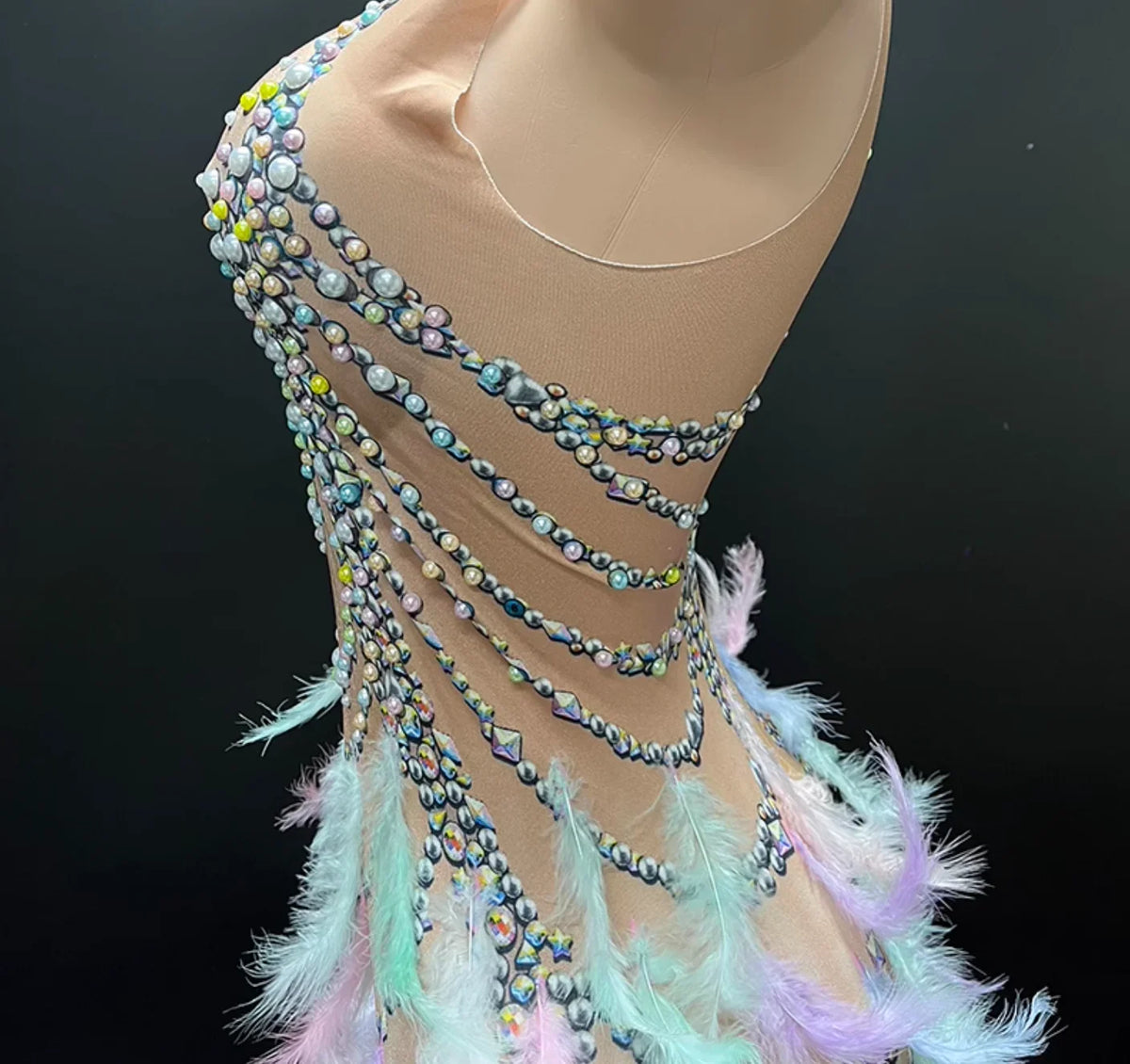 Mannequin wearing a decorative top with beads and feathers on a black background