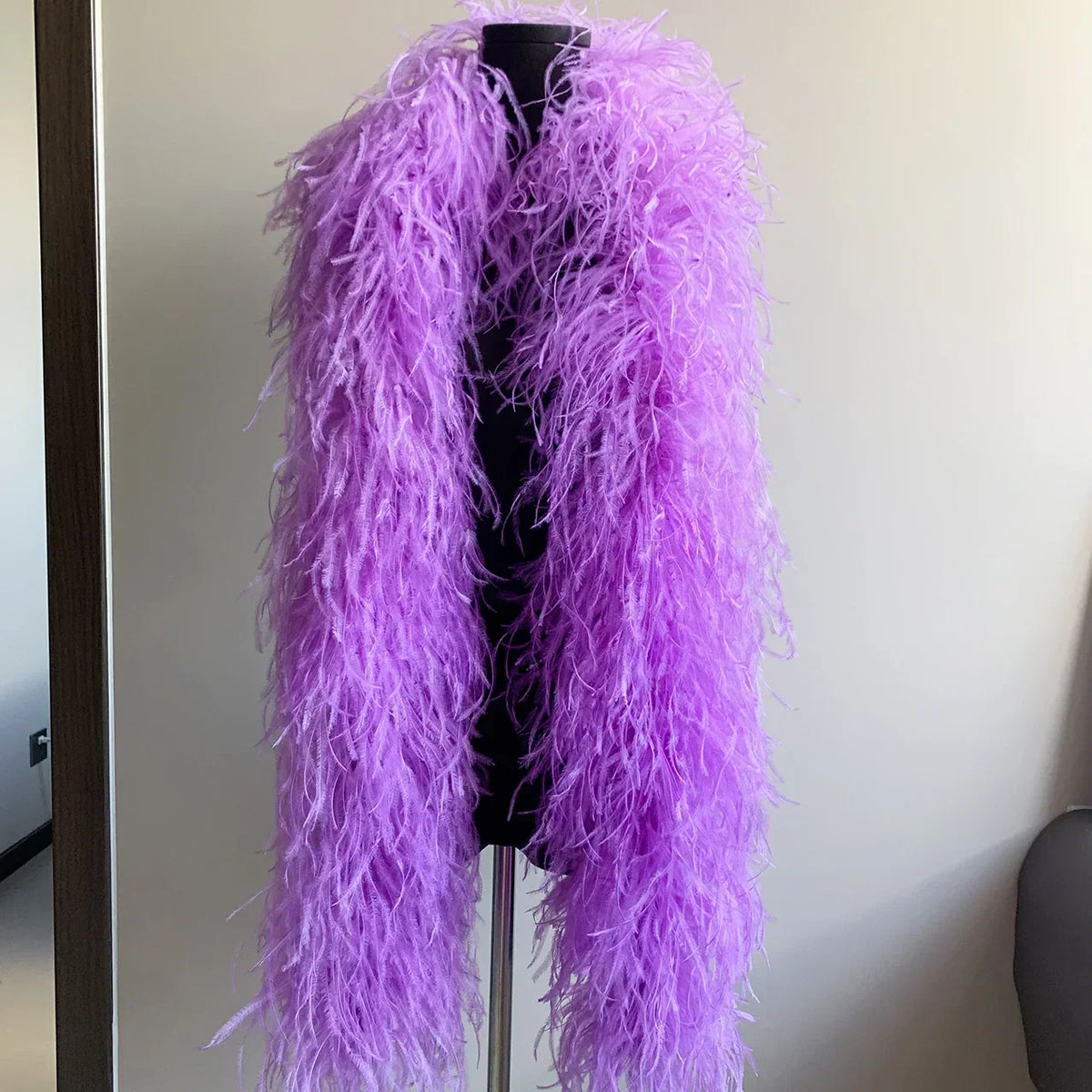 Vibrant purple ostrich feather boa draped on a black mannequin