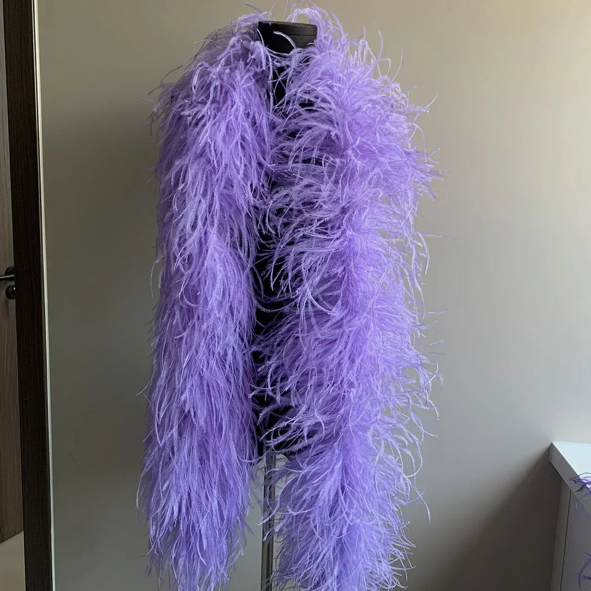 Purple ostrich feather boa displayed on a black mannequin