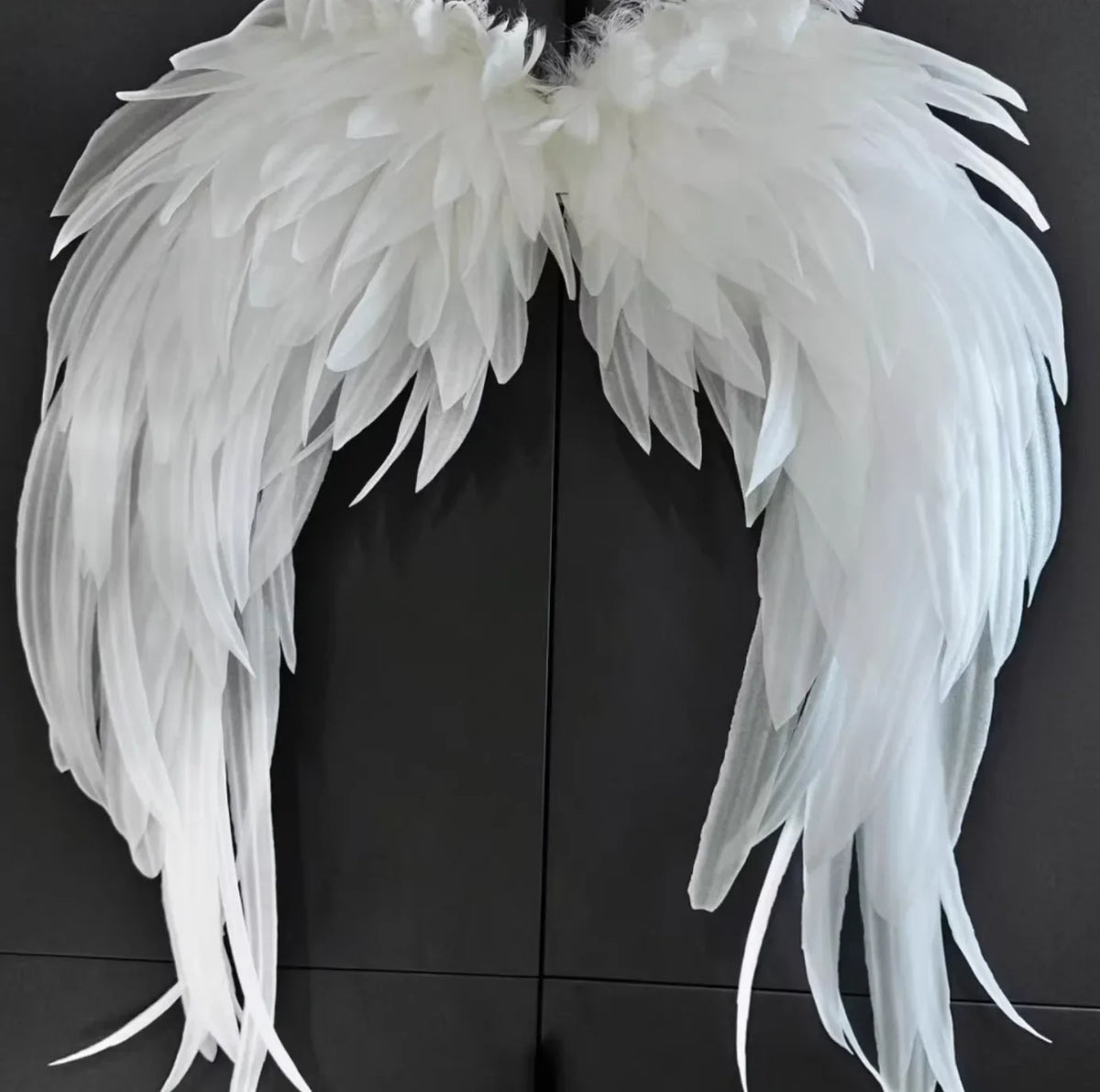 Oversized fluffy white angel feather wings, dramatic costume accessory for photoshoots, cosplay, and themed events.