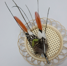 Load image into Gallery viewer, Feathered decorative item on a woven mat with a plain background
