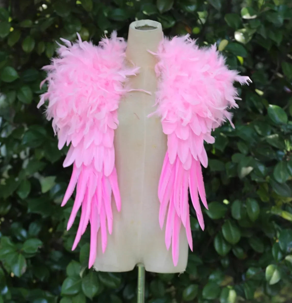 Pink feathered shrug-style wings on a mannequin, lightweight and fluffy for cosplay, Halloween, and events.
