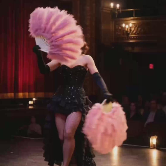 A video demonstration of a large ostrich feather fan being used in a burlesque dance routine.