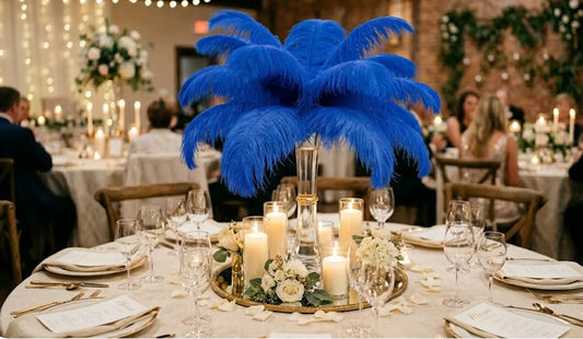 Elegant royal blue ostrich feather centerpiece in a tall glass vase for a sophisticated wedding look.