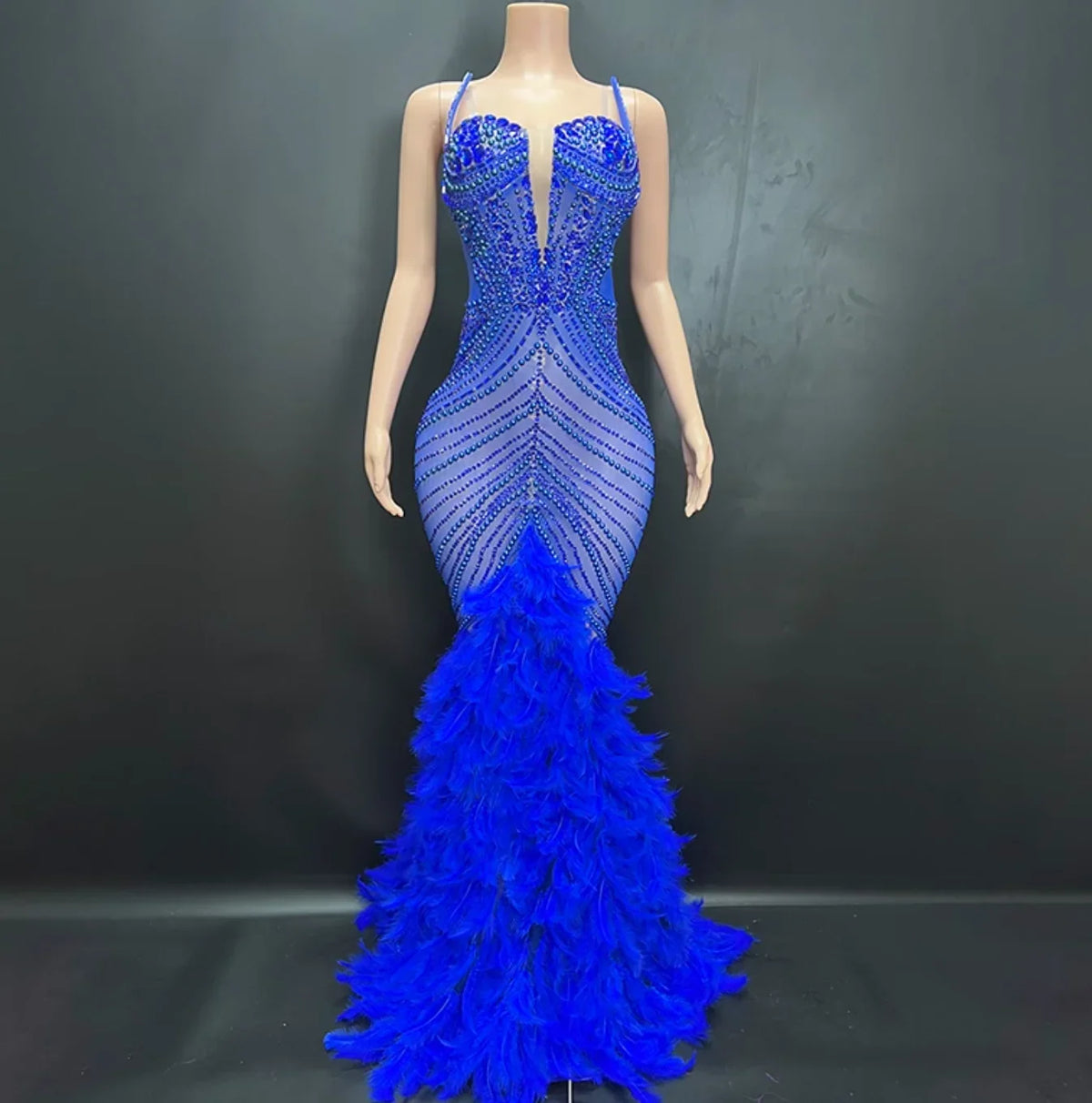 Blue evening gown with feathered skirt on a mannequin against a dark background