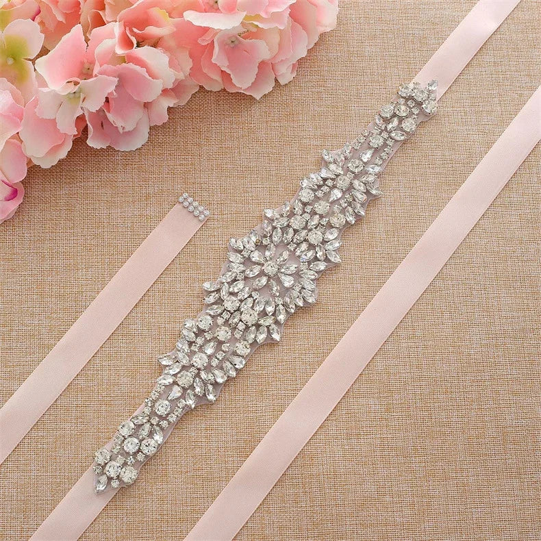 A sparkling thin crystal wedding belt with intricate rhinestone details, elegantly cinching a lace bridal gown.