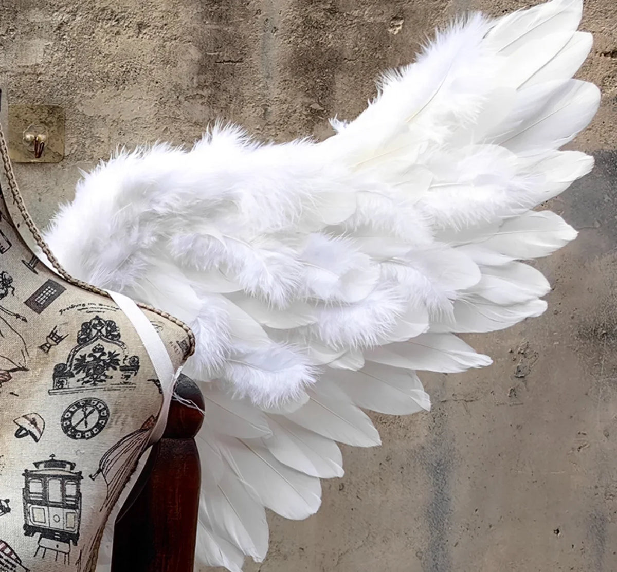 White feather angel wings displayed on a mannequin, showing how the costume prop fits for events