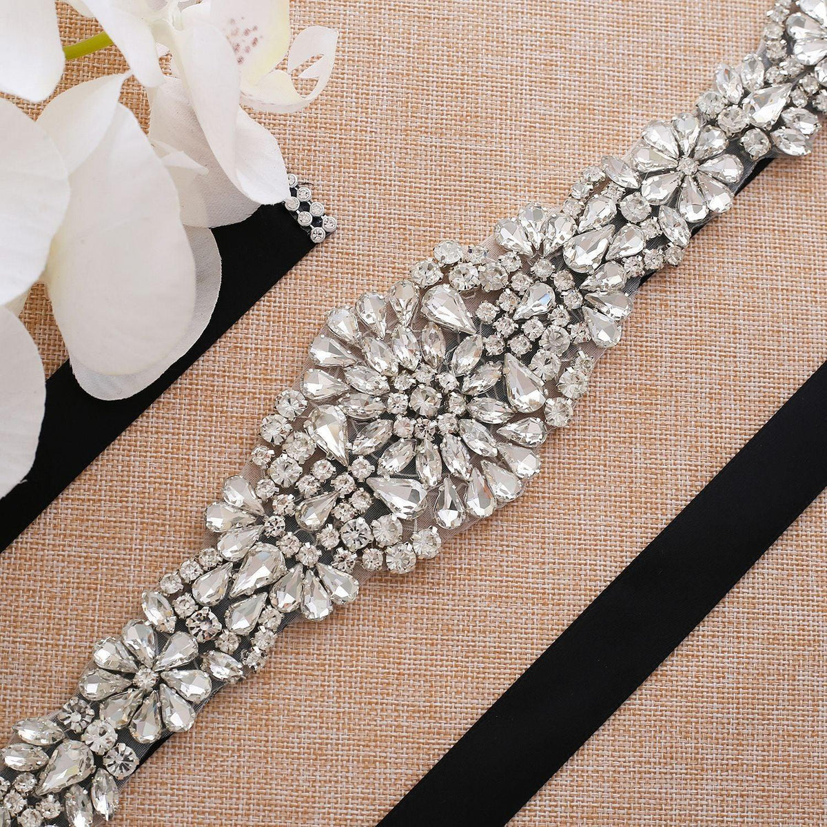 Elegant wide crystal bridal belt featuring a large floral rhinestone design on a black ribbon sash.